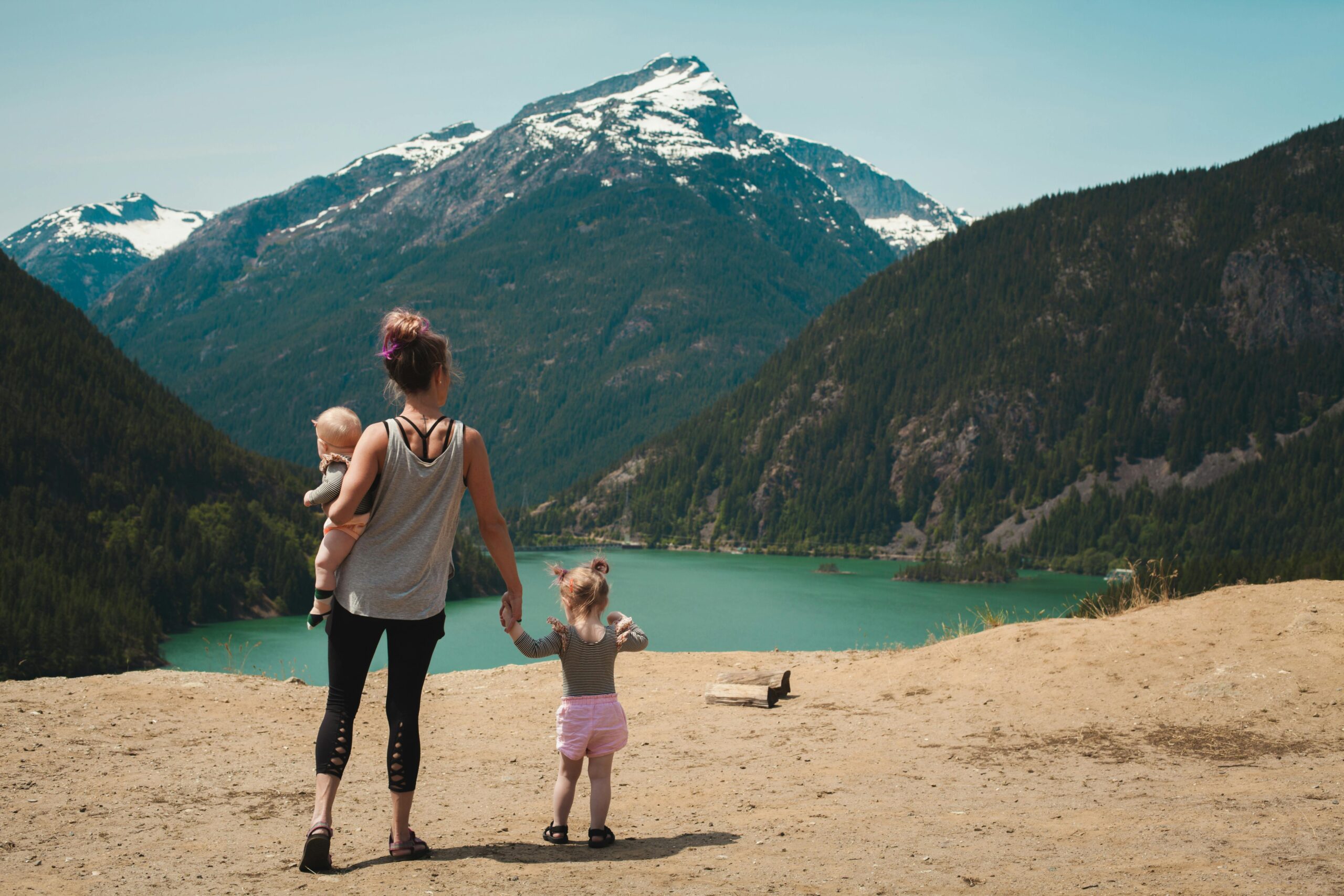 mother-with-children-in-front-of-lake-and-mountain